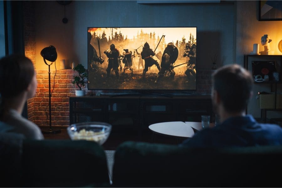 A couple watching a film on a home cinema screen.