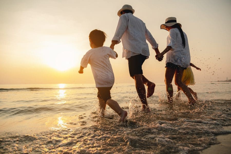 A family paddling in the sea at a beach.