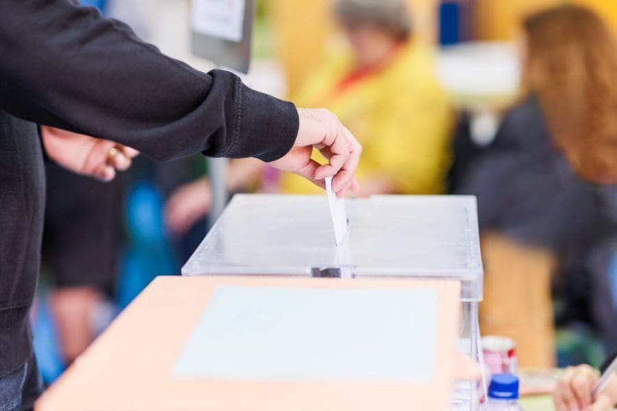 A man voting using a ballot box.