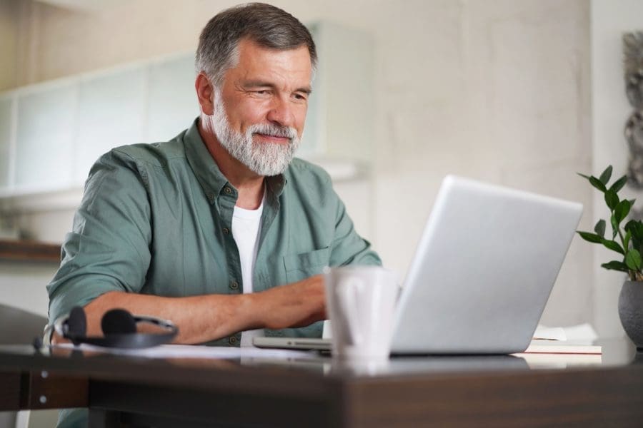 A man using a laptop in a home office.