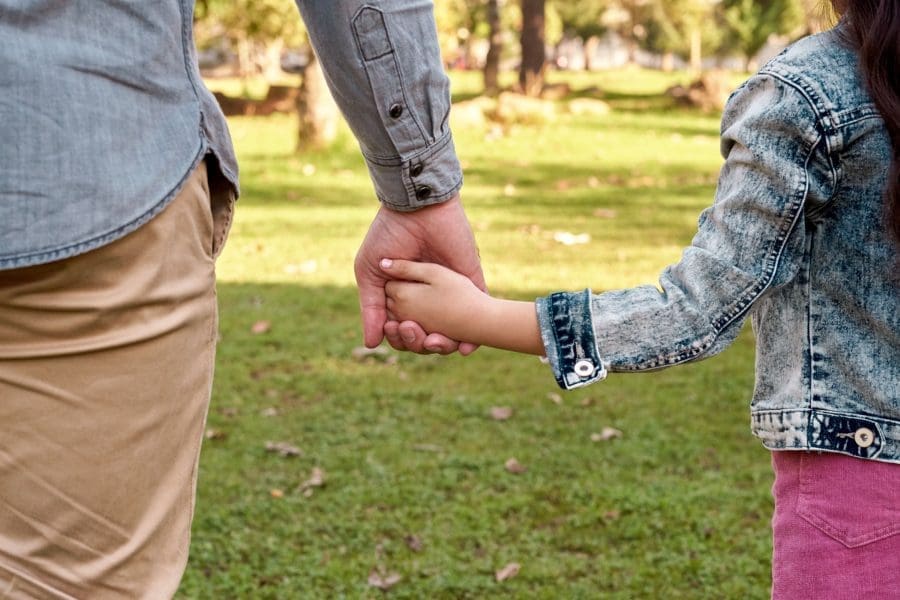 Parent and child holding hands.