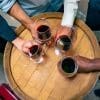 A group of people holding glasses of red wine.