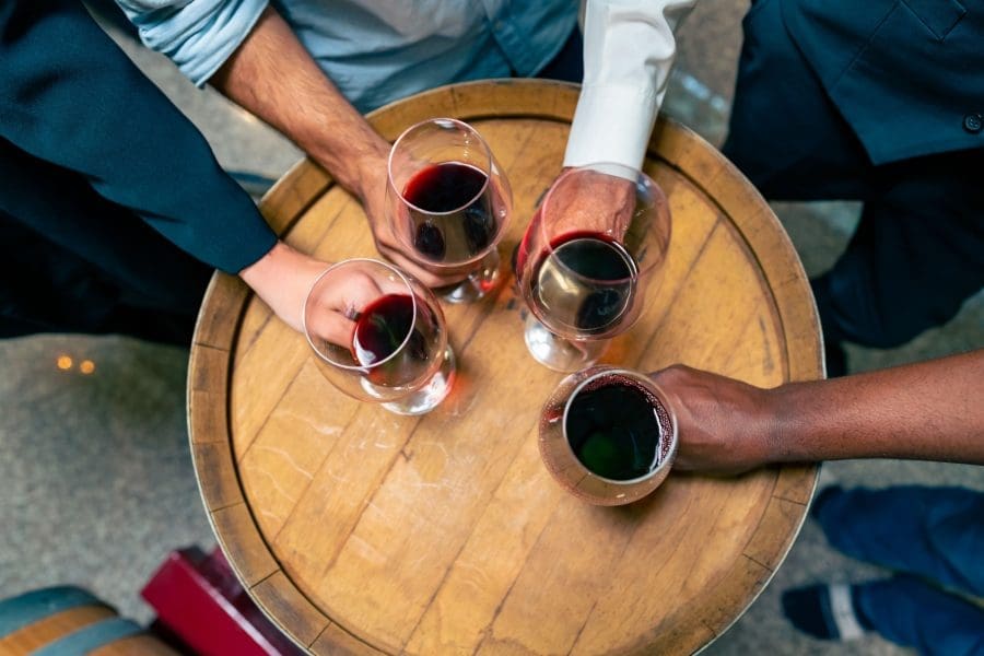 A group of people holding glasses of red wine.