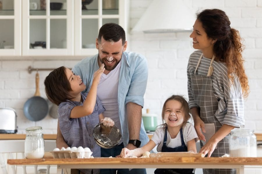 A family with young children baking together.