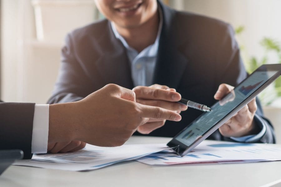 A professional showing a client something on a tablet.