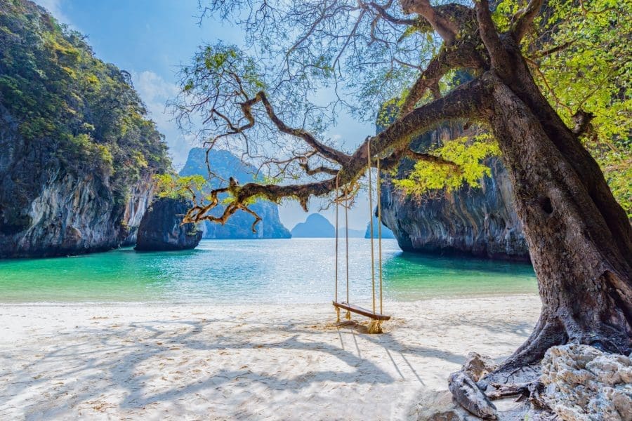 A beach with a swing hanging from a tree in Laos.