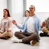 Group of employees meditate in an office