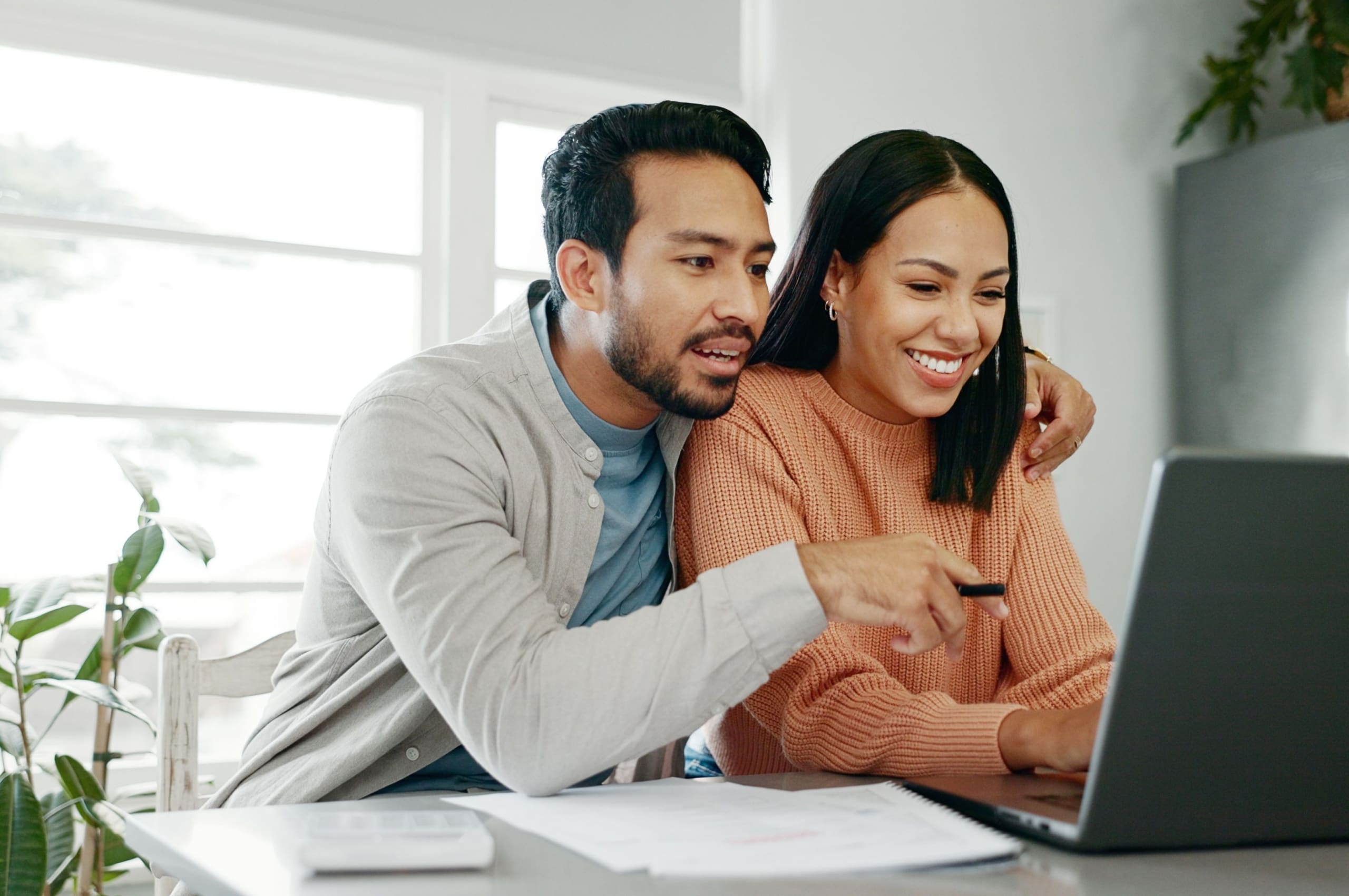 A couple looking at a laptop screen.