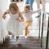 Children running upstairs at home.