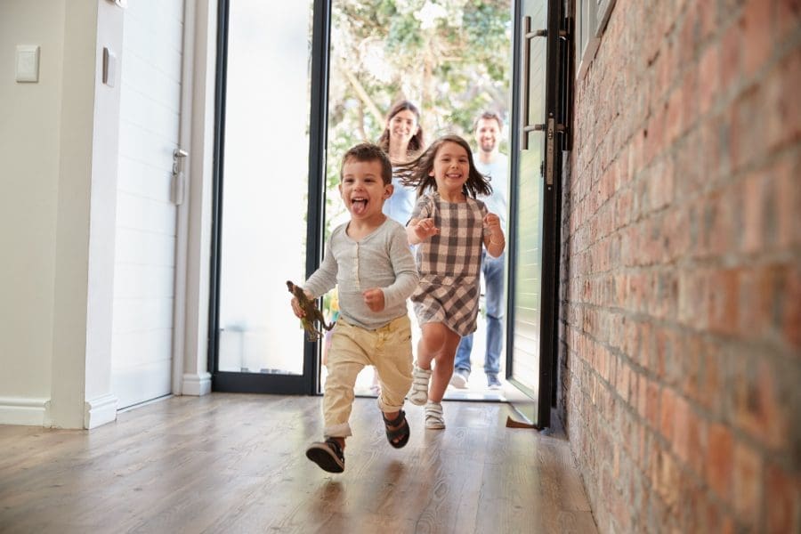 Children running through a front door.